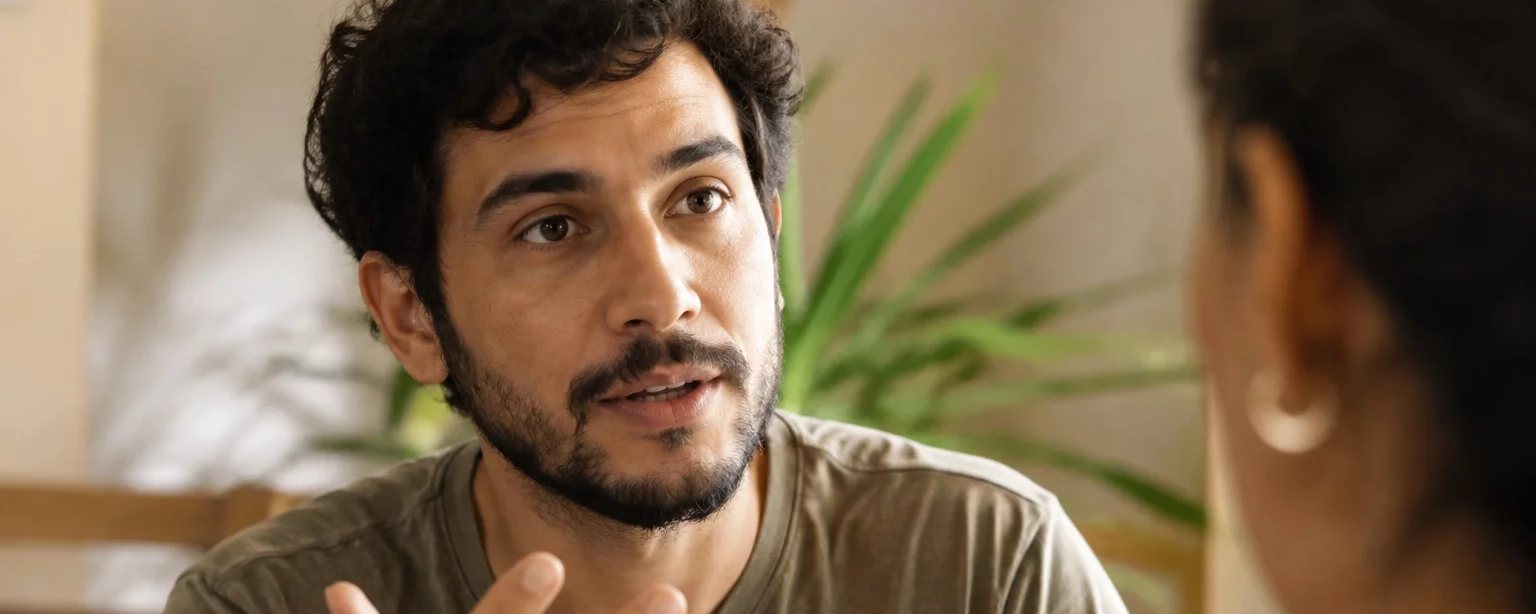 Uma pessoa gesticulando no meio de uma frase, com quem escuta em segundo plano